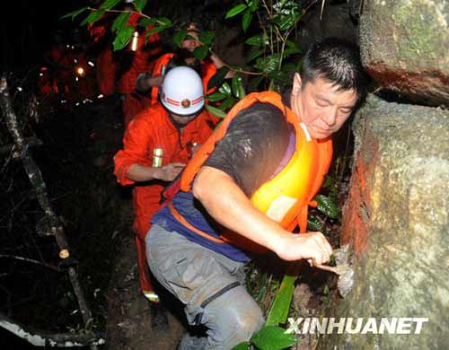 一名網(wǎng)名叫“煙花”的游客（右一）在救援人員的幫助下走出峽谷。新華社發(fā)（李進(jìn)發(fā)攝）