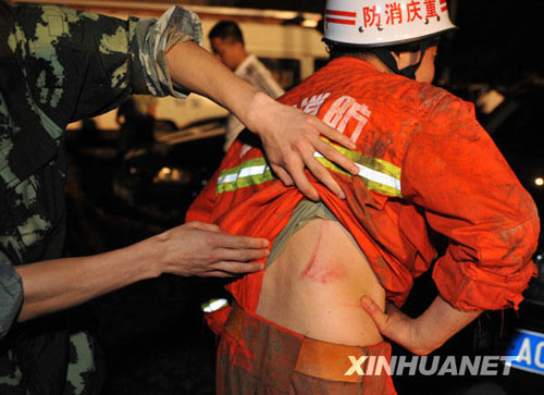 搜救人員在察看戰(zhàn)友被山石劃破的傷口。新華社發(fā)（李進(jìn)發(fā)攝）