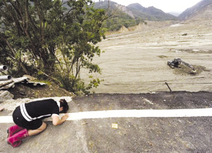 14日，高雄小林村附近的公路上，一名村民悼念在泥石流中喪生的親人。