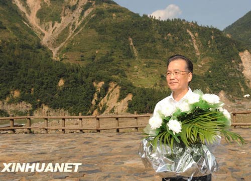 溫家寶總理十分關(guān)注災(zāi)后重建進(jìn)展情況。在國慶節(jié)和中秋佳節(jié)即將來臨之際，他第8次踏上了一直牽掛的這塊土地。在9月24日至26日的三天時間里，他奔波穿行于地震重災(zāi)區(qū)的城鄉(xiāng)間，為節(jié)省時間，吃飯盡量安排在火車上；連續(xù)兩個晚上主持召開會議，就災(zāi)后恢復(fù)重建的一系列重大問題進(jìn)行研究部署。這是9月24日，溫家寶在青川縣紅光鄉(xiāng)東河口村地震遺址祭奠臺獻(xiàn)花。新華社記者黃敬文攝