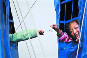 玉樹懷德兒童福利院，女孩們在帳篷間傳遞千紙鶴、手鏈等，互相打氣鼓勵。