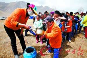 吃飯前，老師給孩子們舀水洗手。