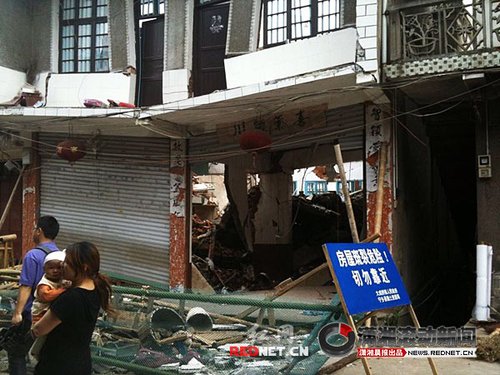 大成橋鎮(zhèn)老街，16號門面，房梁垮塌、房屋變形，門前的卷閘門已是一邊高一邊低。 圖/瀟湘晨報(bào)滾動(dòng)新聞?dòng)浾?劉剛