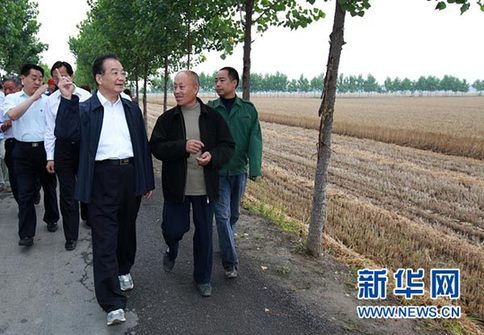 這是6月9日，溫家寶在長(zhǎng)葛市石象鄉(xiāng)坡李王村的田間小路上與坡李王村支部書(shū)記李福成邊走邊聊。新華社記者龐興雷攝