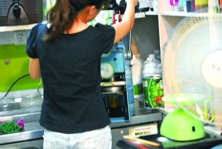 昨日，沙坪壩區(qū)一飲料店，店員在用添加劑勾兌果汁