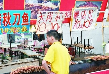 被查后，美食街上的'羊肉串'的'羊'字被涂抹了。