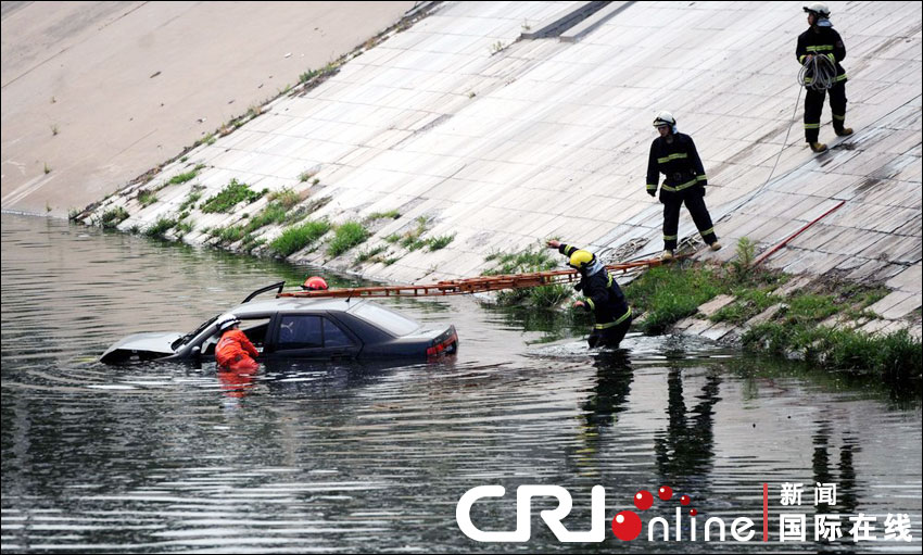 三名男子搭救上岸后，消防員下水在車內(nèi)尋找兇器。