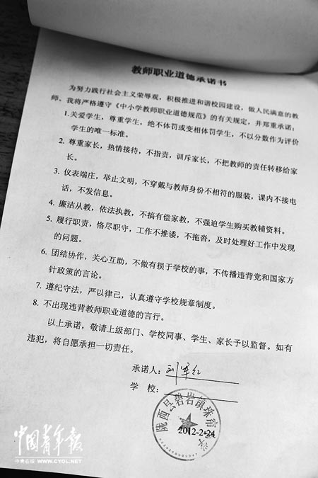 劉軍紅簽字的教師職業(yè)道德承諾書。本報(bào)記者 張鵬攝