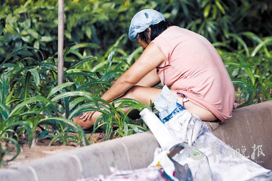 疑似精神病婦女下體裸露，在綠化帶喃喃自語(yǔ) 羊城晚報(bào)記者 何奔攝