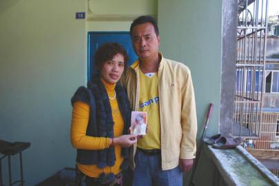 李濤夫婦拿著龍龍當年的照片合影。張勇攝