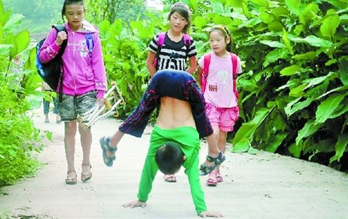 倒立行走去上學(xué) 堅(jiān)強(qiáng)癱瘓男孩感動網(wǎng)友。圖據(jù)山東商報(bào)