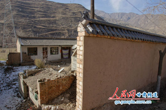 甘肅漳縣殪虎橋鄉(xiāng)東橋村的“遮羞墻”擋住農(nóng)戶房屋（人民網(wǎng)記者 高翔 張鵬 隋欣 攝）