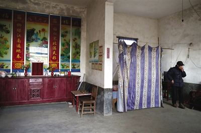 閔擁軍家是一棟二層小樓，父母住在簾子后面的地方。