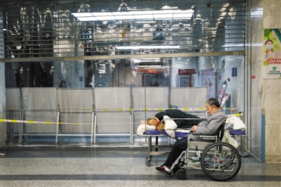 12月20日凌晨，一家醫(yī)院急診大廳，一位病人的病床設(shè)在急診分診臺附近。