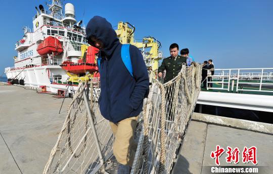 圖為24名“驢友”的“導(dǎo)游”被邊防的工作人員帶下船接受調(diào)查。 駱云飛 攝