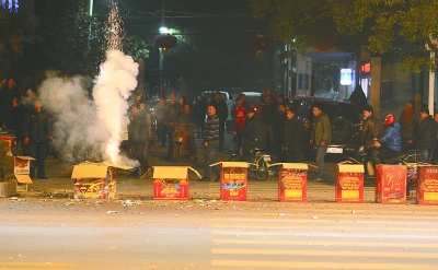 上圖：昨晚7點49分，在漢口建設大道802號長江委酒寶蕩小區(qū)門前的人行橫道上，有人大肆燃放煙花爆竹，硝煙彌漫，空氣污染。 記者金思柳 攝