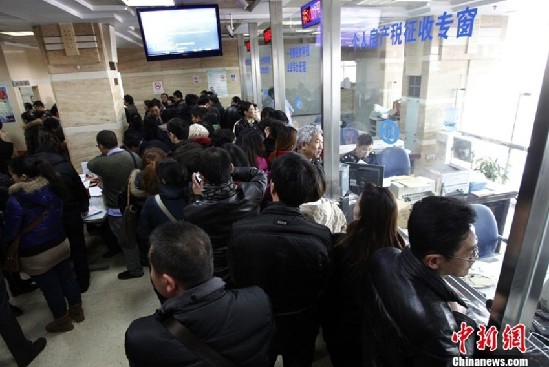 3月3日，上海二手房交易中心，窗口前排隊的交易者。3月1日，“新國五條”細(xì)則發(fā)布，其中明確二手房交易中的個人所得稅將會按照個人所得的20%征收。受此影響，中新社發(fā) 湯彥俊 攝