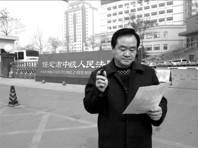 焦占軍在法院門口拿著決定書，無語站立。京華時報記者孫思婭攝