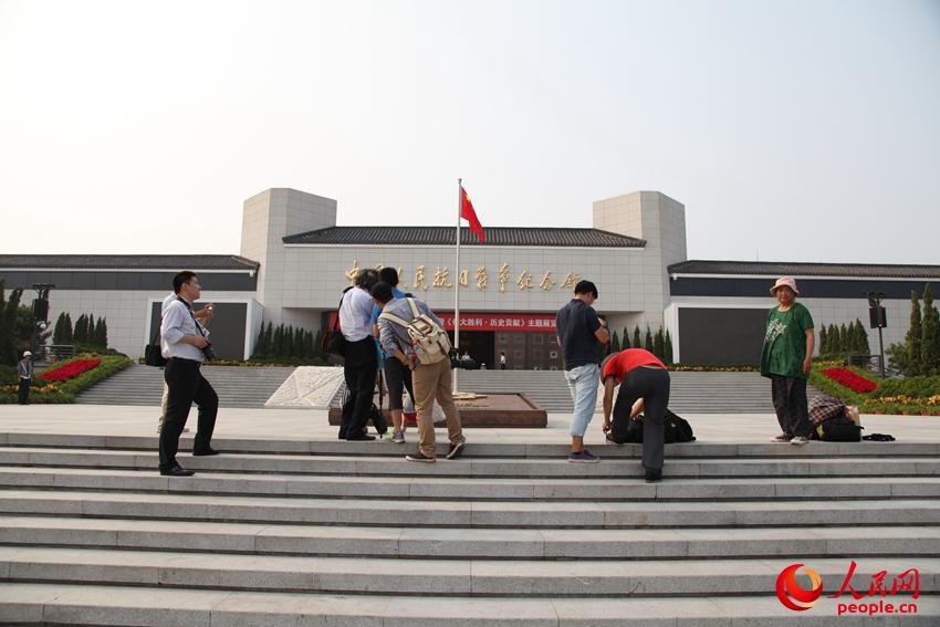 參觀展覽的觀眾在紀(jì)念館前拍照留念。邱越攝